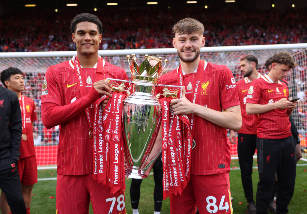 Liverpool defender Jarell Quansah posing with the Premier League trophy alongside teammate Conor Bradley