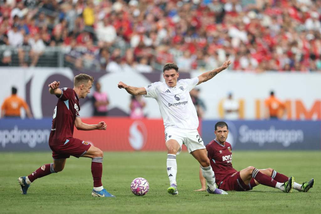Manuel Ugarte of Manchester United controls the ball whilst under pressure from James Ward-Prowse of West Ham