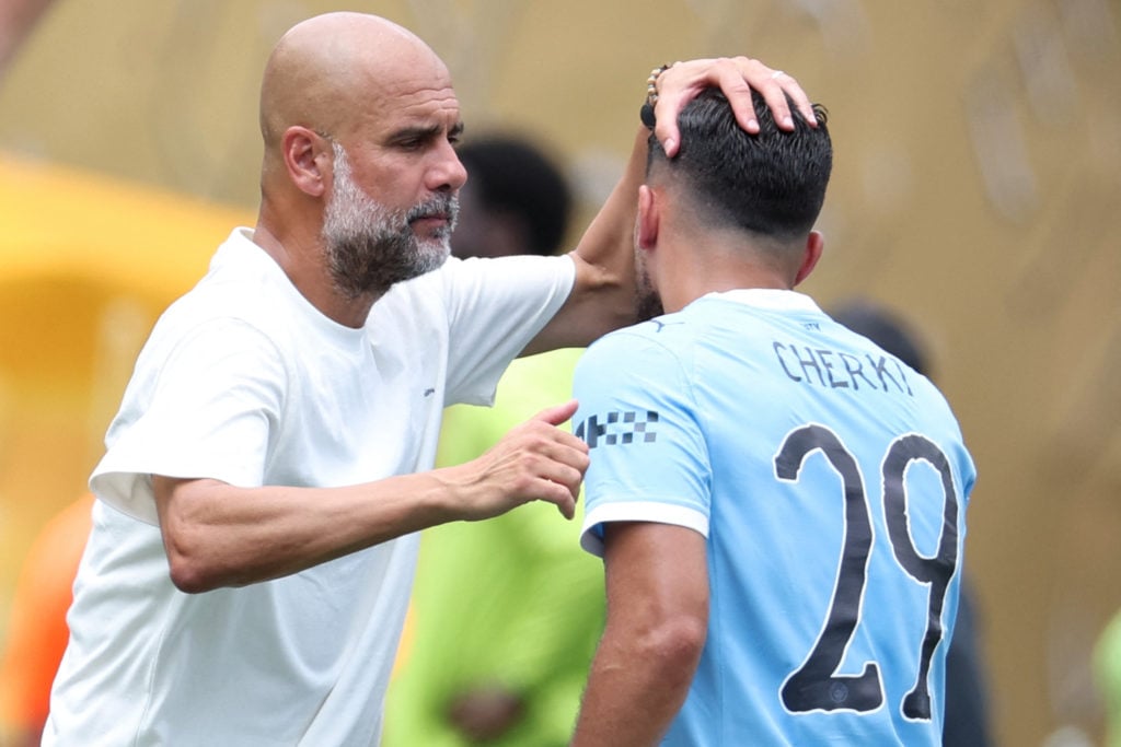 Manchester City's Spanish head coach Pep Guardiola congratulates Manchester City's French midfielder #29 Rayan Cherki
