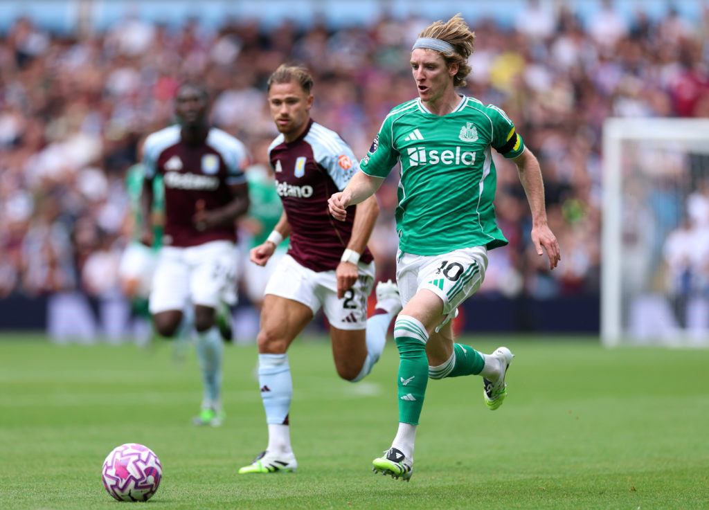 Anthony Gordon of Newcastle United runs with the ball whilst under pressure from Matty Cash of Aston Villa