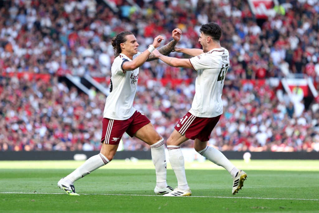 Riccardo Calafiori of Arsenal (L) celebrates scoring his team's first goal with teammate Declan Rice during the Premier League match between Manchester United and Arsenal at Old Trafford.