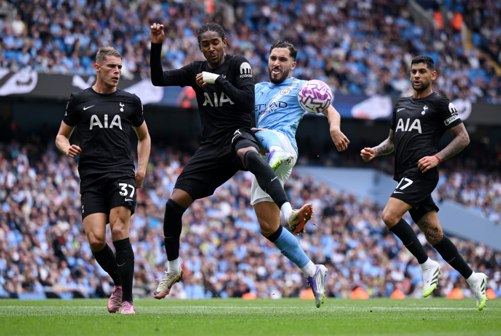 Djed Spence of Tottenham Hotspur is challenged by Rayan Cherki of Manchester City during the Premier League match between Manchester City and Tottenham