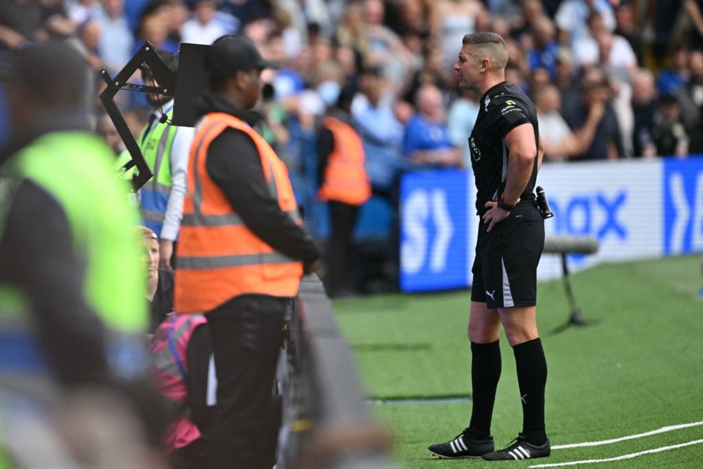 Rob Jones checks the pitch-side monitor before disallowing a Fulham goal during the English Premier League football match between Chelsea and Fulham at Stamford Bridge