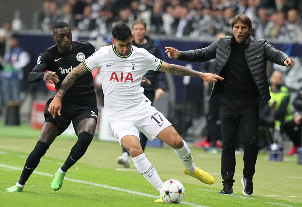 Frankfurt's French forward Randal Kolo Muani (L) and Tottenham Hotspur's Argentinian defender Cristian Romero (C) vie for the ball while Tottenham Hotspur's Italian head coach Antonio Conte