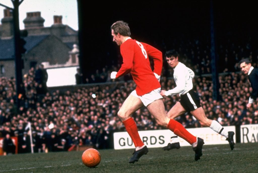 Denis Law dribbles with the ball for Manchester United against Fulham