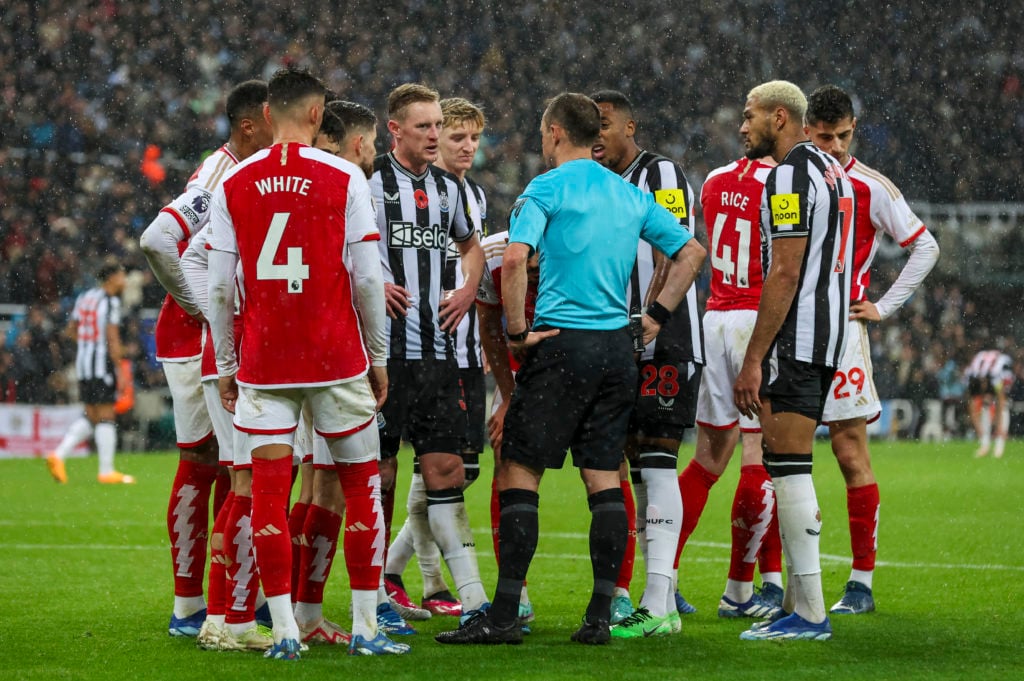 Players surround referee Stuart Attwell as VAR checks the Newcastle United goal during the Premier League match between Newcastle United and Arsenal