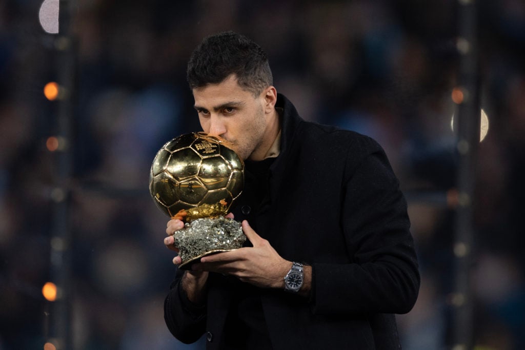 Rodri poses with his Ballon d'Or award during Manchester City vs Tottenham