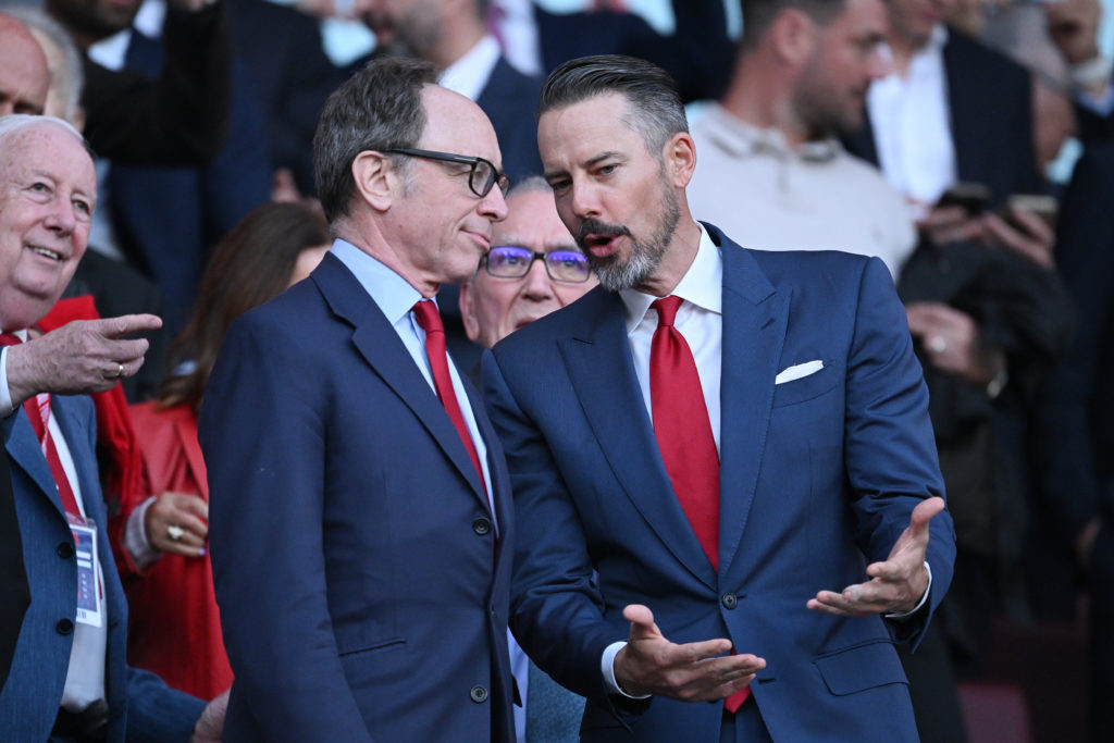 Josh Kroenke and Tim Lewis converse at an Arsenal match at the Emirates Stadium