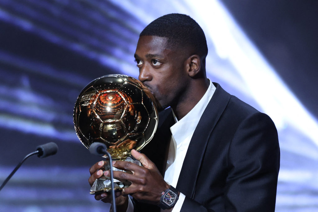 Paris Saint-Germain's French forward Ousmane Dembele kisses the Ballon d'Or award during the 2025 Ballon d'Or France Football award ceremony.