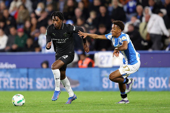 Reigan Heskey of Manchester City runs with the ball whilst under pressure from Jay Smith-Sway of Huddersfield Town during the Carabao Cup Third Round match between Huddersfield Town and Manchester City