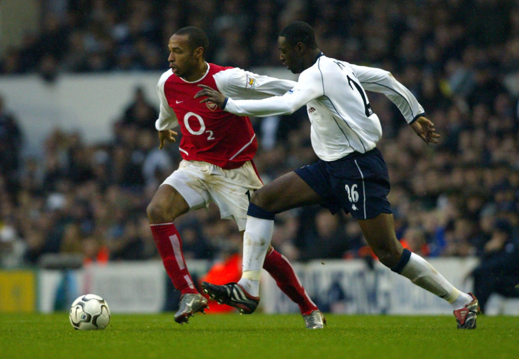 Ledley King of Tottenham Hotspur tries to tackle Thierry Henry of Arsenal