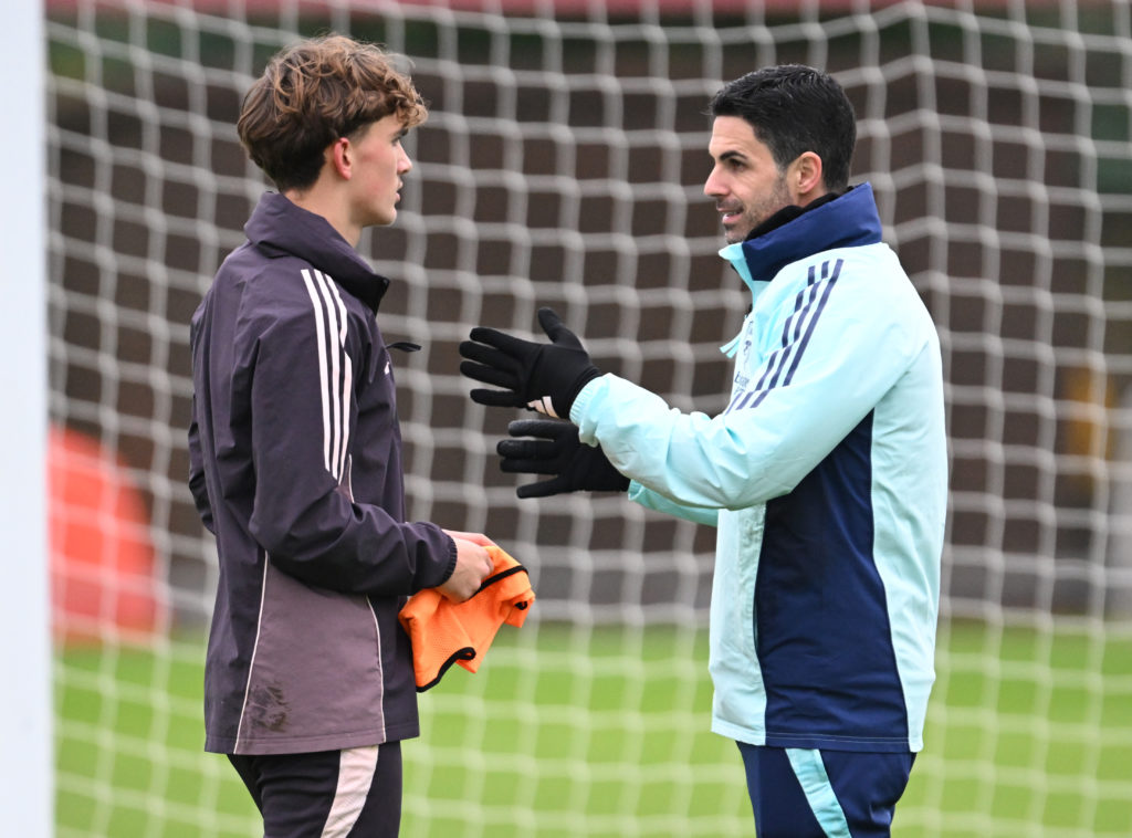 Mikel Arteta gives advice to Max Down during an Arsenal training session at Sobha Realty Training Centre