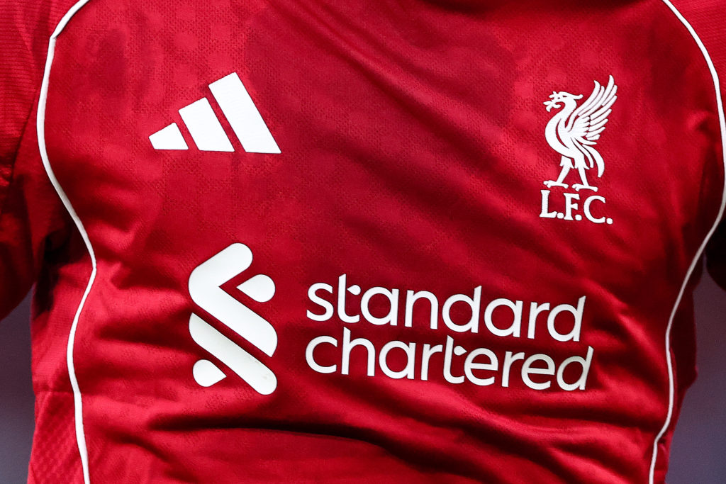 A closeup shot of Liverpool's 2025-26 home kit, with Adidas and Standard Chartered branding prominent