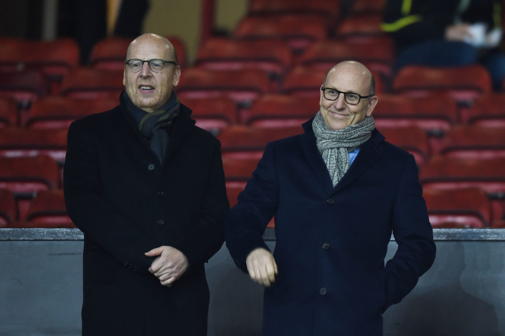 Manchester United co-chairmen Avram Glazer (left) and Joel Glazer (right) smile as they look on from the stands at Old Trafford
