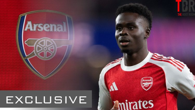 Bukayo Saka looks on alongside an Arsenal badge and an exclusive TBR Football banner