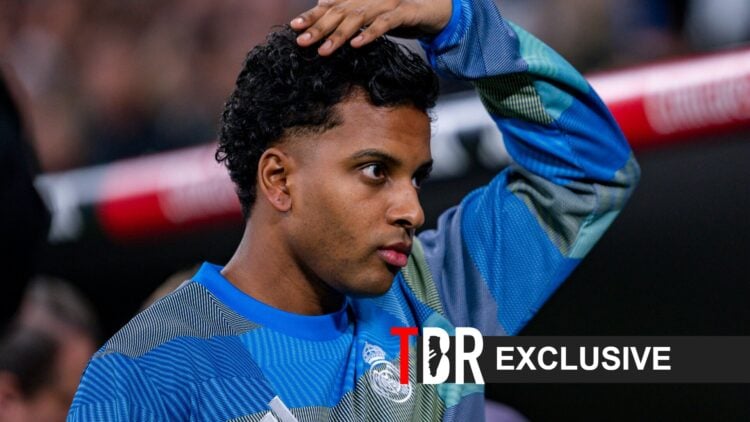 Rodrygo of Real Madrid looks on and a TBR Football banner